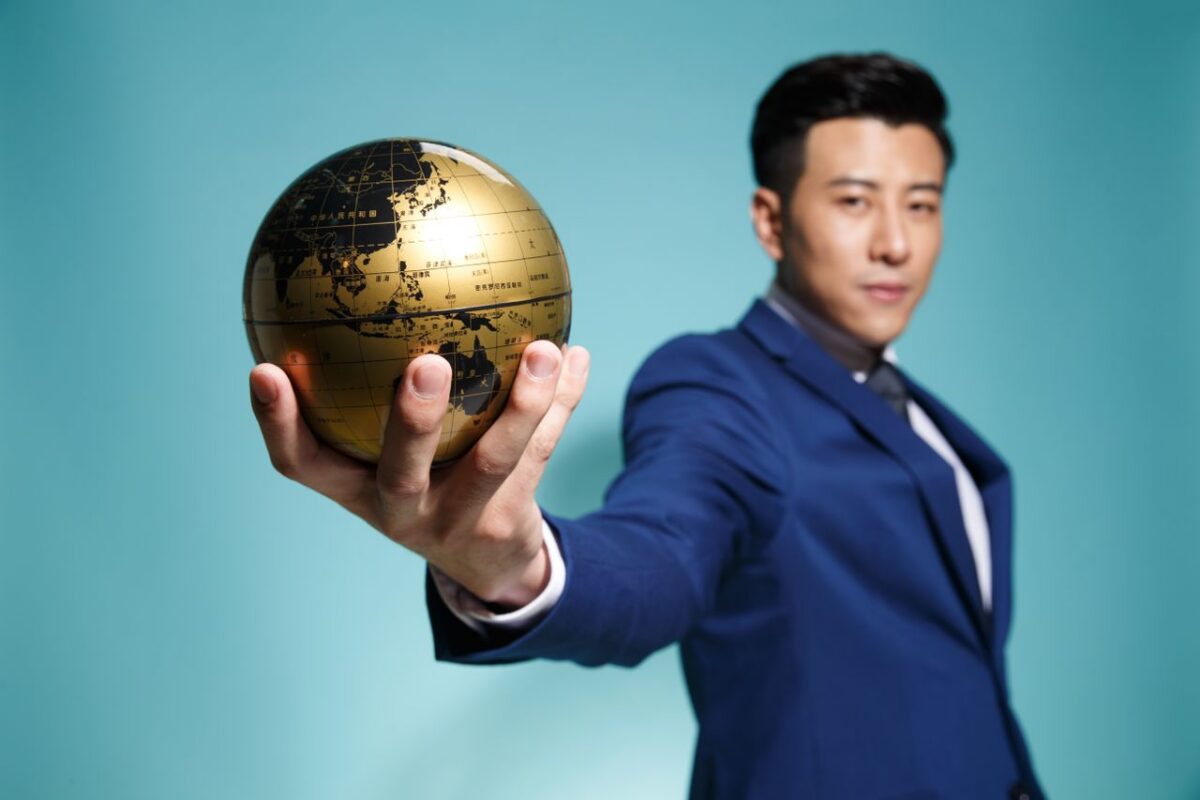 A chinese businessman holding a globe